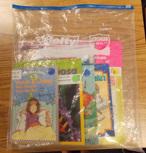 This shows the larger Hefty book bag (2.5 gallon) with a smaller Ziploc baggie (1 gallon) inside. The larger book bag stays at school, and any books students want to take home at night go into the small Zip-loc baggie.